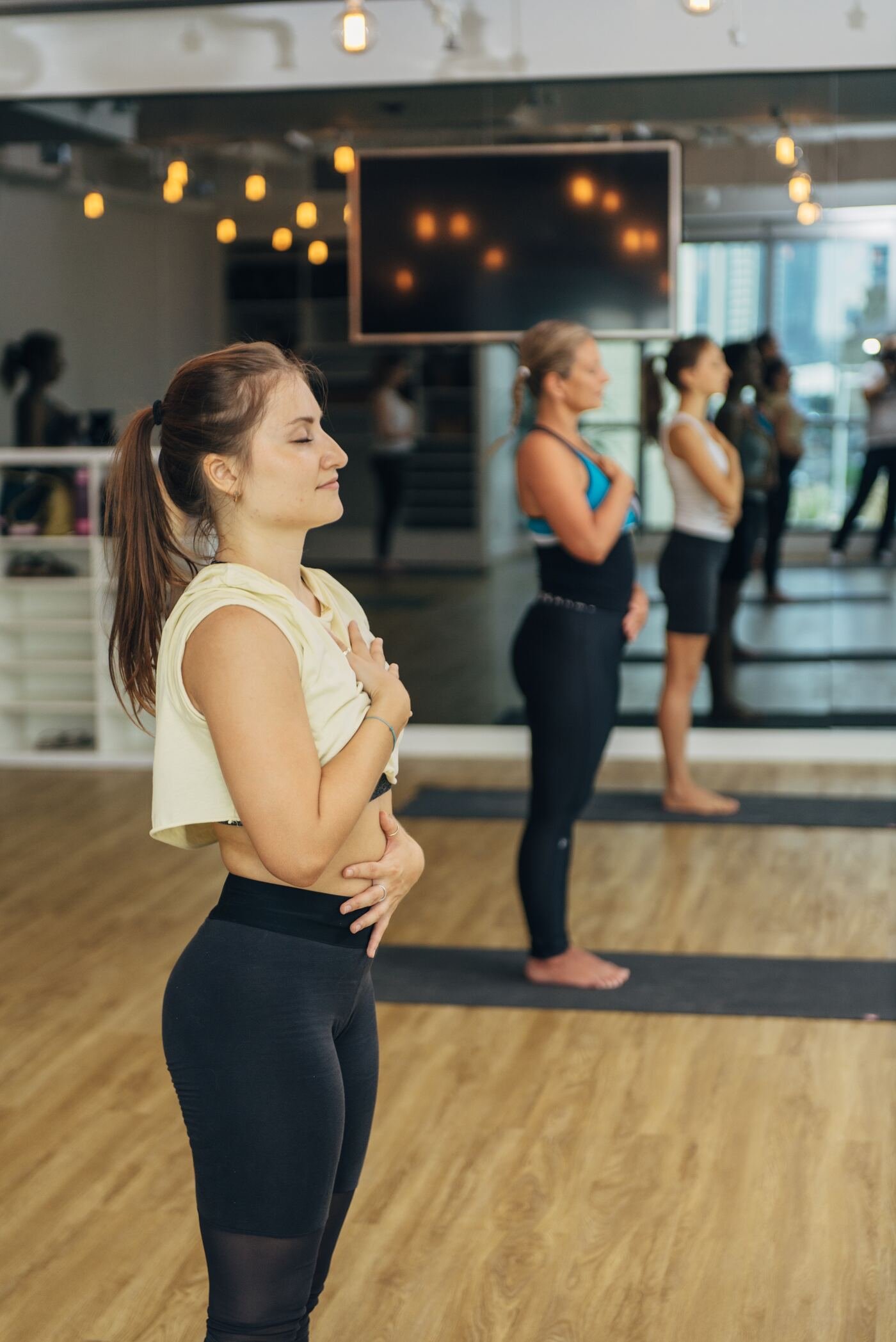A woman breathing with her hand on her chest during a movement class